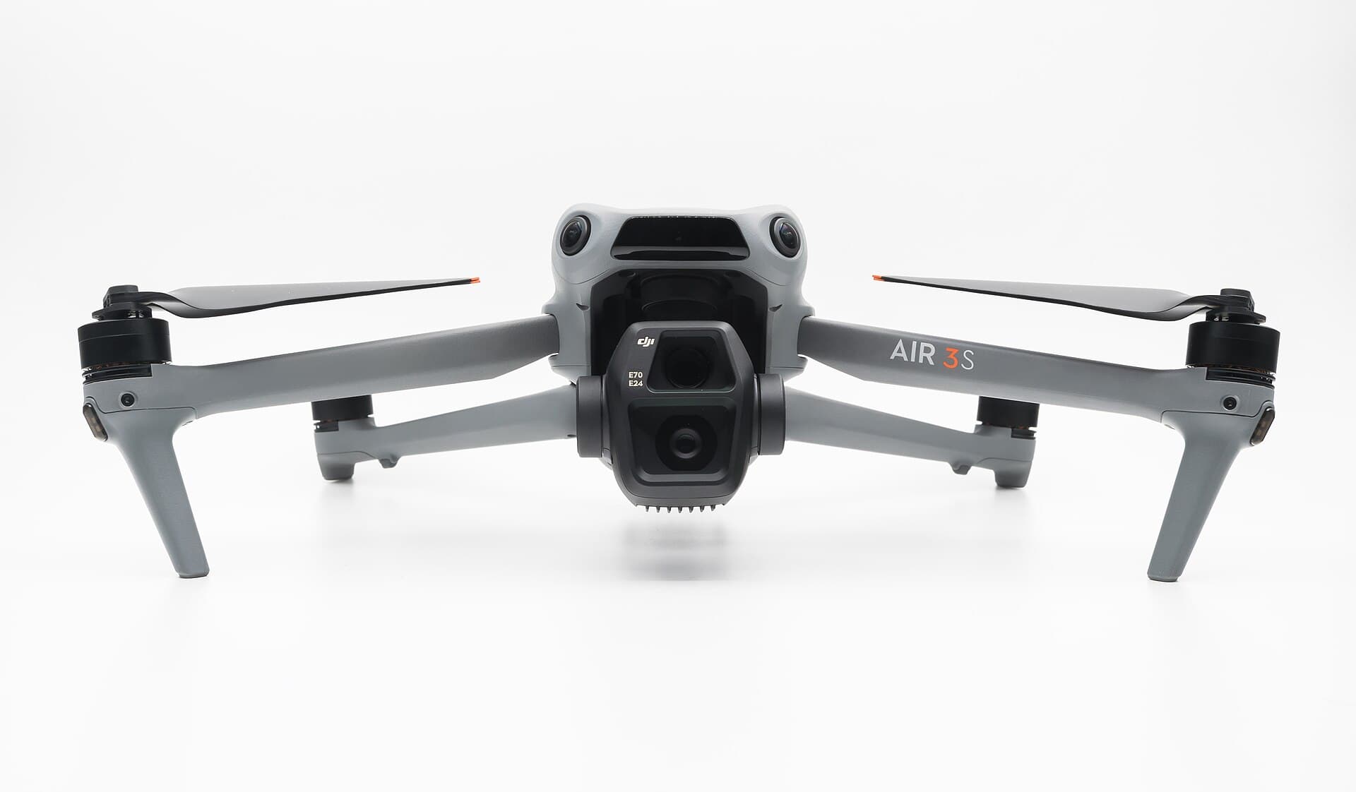 DJI Air 3S camera drone photographed head-on against a white background, arms extended, dual-lens gimbal camera centred